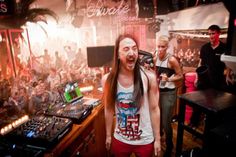 a man with long hair standing in front of djs