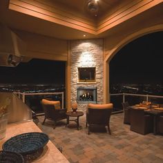 a living room filled with furniture and a fire place next to a stone wall covered in lights