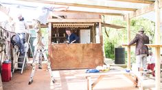 three men are working on building a house