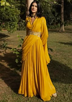 Introducing our Yellow Sharara Saree Set, a perfect blend of elegance and comfort. Crafted on a shimmering lurex fabric, this ready-to-wear saree exudes allure. The matching full-sleeved shirt-style blouse features delicate embroidery on the collar, adding a touch of sophistication. Complete the look with the stunning embroidered belt for that extra touch of chic. Ideal for festive occasions like Haldi and Mehendi ceremonies, this saree set is a must-have addition to your wardrobe. Composition : Saree, Blouse - Lurex Care: Dry Clean Only and Vacuum Storage This product can be customized for sleeves, length of blouse and neckline Delivery : 4-6 weeks as the product is hand crafted. Check Size Guide or choose MySize for free customisation (All Sizes above XL can be made at 15% additional cos Sharara Saree, Yellow Sharara, Haldi Ceremony Outfit, Haldi Dress, Mehendi Outfit, Embroidery Mirror, Haldi Outfit