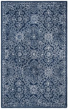 a blue rug with an intricate design on the front and back side, in white