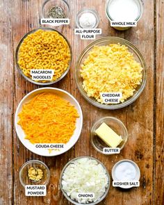 the ingredients for macaroni and cheese laid out in bowls on a wooden table