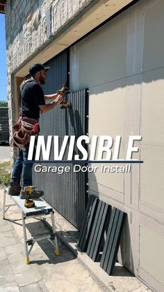 a man is painting the side of a building with an invisible garage door installer