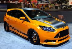 an orange and black car is on display