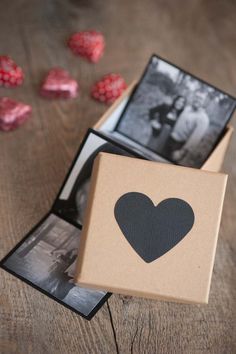 an open box with a black heart on it and some candy in the back ground