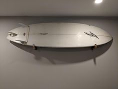 a white surfboard mounted to the wall