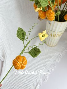 crocheted flowers in a vase on a white tablecloth with the words garden written across it