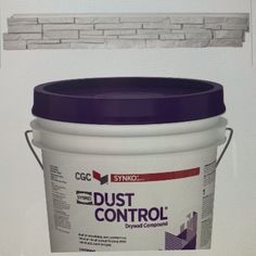 a bucket of dust control sitting on top of a counter next to a brick wall