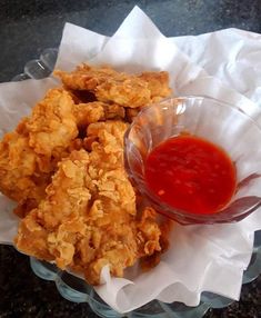 some fried food is in a bowl with ketchup