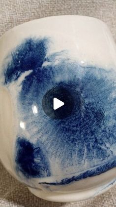 a white and blue vase with a black hole in it