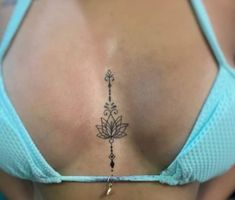 the back of a woman's stomach with a lotus tattoo on her left side