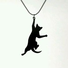 a black cat silhouetted on a ball chain with its paw in the air as if to catch a frisbee