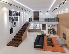 an open living room with stairs and pictures on the wall