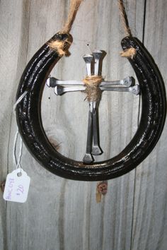 a cross made out of black leather hanging from a rope