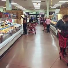 people shopping in a grocery store with carts