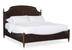 a wooden bed with white sheets and pillows