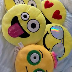 three yellow pillows with faces and hearts on them