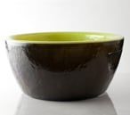 a green bowl sitting on top of a white table