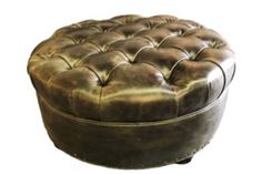 a brown leather ottoman sitting on top of a white floor