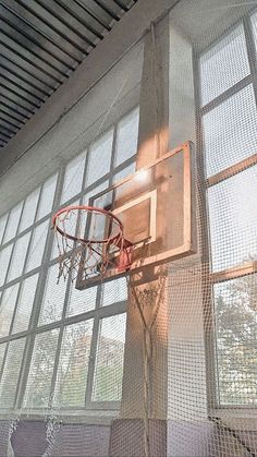 an indoor basketball hoop in front of large windows