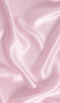 a pink silk background with very soft folds and smooth lines on the fabric in this image