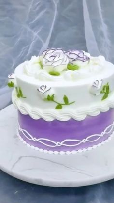 a white and purple cake sitting on top of a table