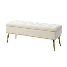 an upholstered bench with gold legs and studded trimmings on it