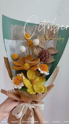 a bouquet of crocheted flowers is held by someone's hand with the words gather above it