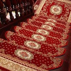 red and gold rugs on the floor in a room with wooden stairs, carpeted floors