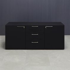 a black cabinet with three drawers in front of a wall