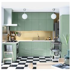 a kitchen with green cabinets and checkered flooring