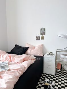 a black and white checkered floor in a bedroom with pink sheets on the bed