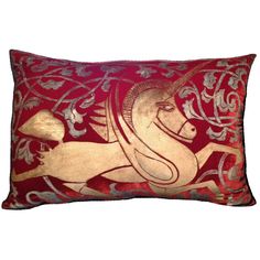 a red and gold pillow with a horse on it