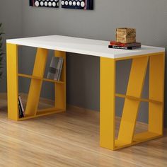 a white table sitting next to a yellow book shelf on top of a hard wood floor