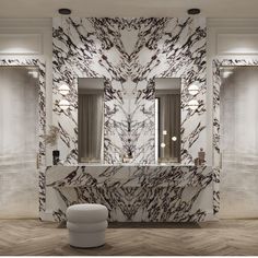 a bathroom with marble walls and flooring, mirrors on the wall above the sink