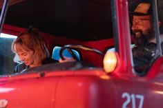 a man and woman sitting in the driver's seat of a firetruck