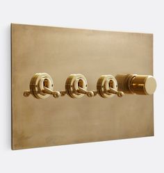 four brass handles on a wall mounted light switch