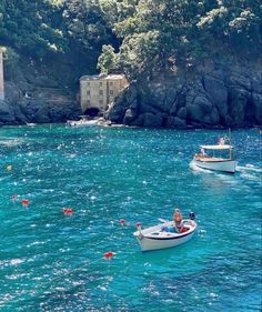 two small boats are in the blue water