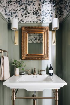 a white sink sitting under a mirror next to a wall mounted faucet in a bathroom