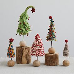 small wooden christmas trees are lined up on top of wood stumps with candy decorations