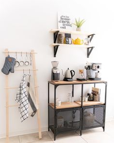 there is a shelf with cups and mugs on it next to a towel rack