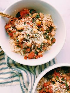 two white bowls filled with food on top of a table