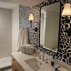 a white sink sitting under a bathroom mirror next to a wall mounted faucet