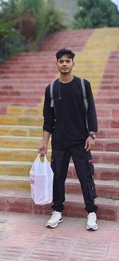 a man standing on steps with a bag in his hand