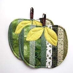 three green and yellow potholders with leaves on them, one is made from fabric