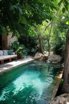 an outdoor swimming pool surrounded by trees and rocks