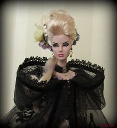 a doll with blonde hair wearing a black dress