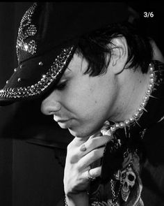 black and white photograph of a man with his hand on his face wearing a hat