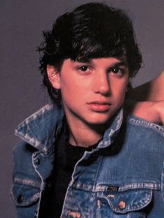 a young man wearing a jean jacket and black shirt