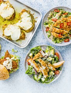 four plates with different types of food on them, including breads and salads